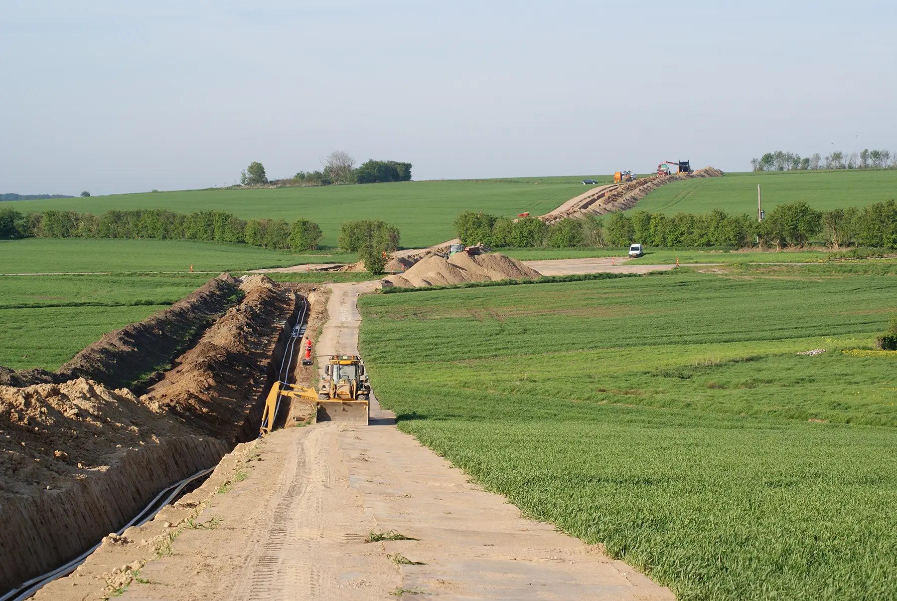 Tarchon Interconnector onshore pipeline construction with trench, laid pipes, and heavy machinery across rural countryside.